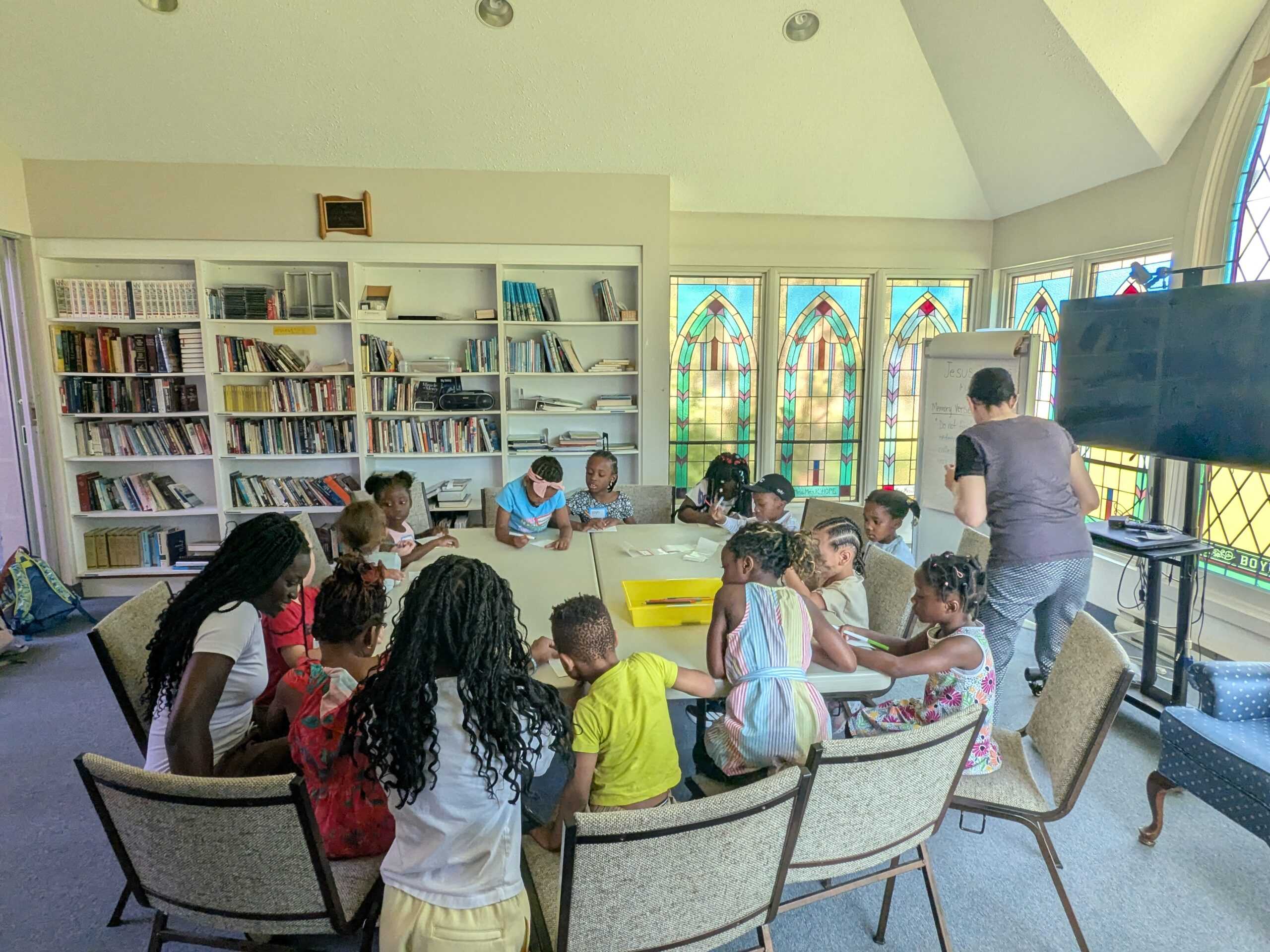 Kids sitting around a table doing an activity.