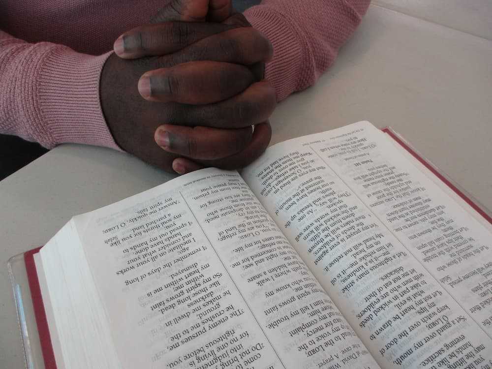 A church member praying over the Bible.