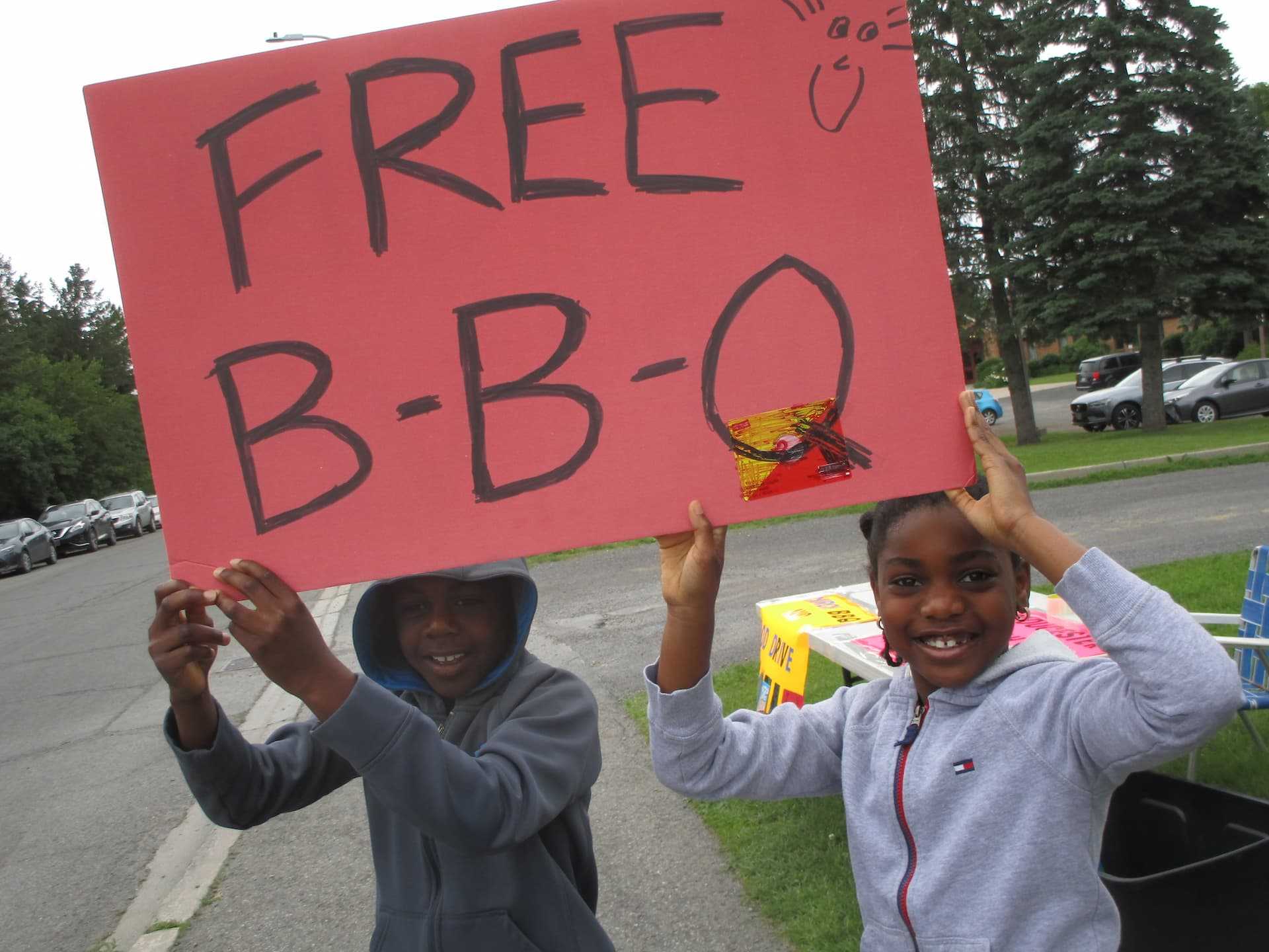 Two kids helping out at a BBQ.